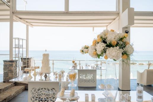Outdoor wedding reception on the beach with elegant setup.