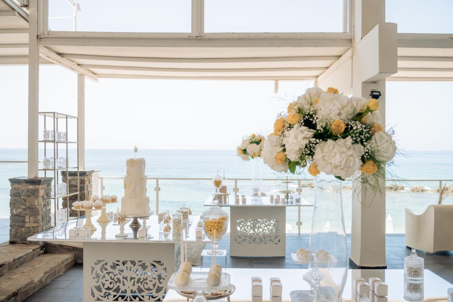 Outdoor wedding reception on the beach with elegant setup.