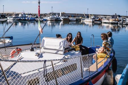 Motorbootfahrt vom Hafen aus, bei Sonnenschein, ruhiger See und mediterraner Landschaft.