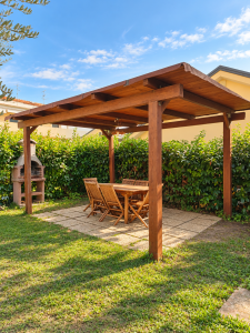 Privater Garten mit einer Holzpergola, einem Tisch und Stühlen für den Außenbereich, einem gemauerten Grill und einer grünen Hecke.